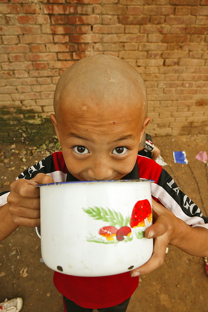 young boy at breakfast, one of many new Kung Fu schools in Dengfeng, near Shaolin, Song Shan, Henan province, China, Asia