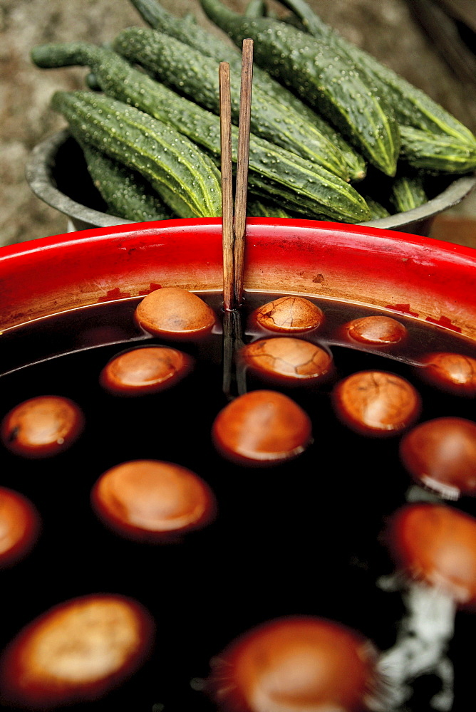 Cucumbers and hard boiled eggs cooked in black tea, soy sauce and spices, typical snack, China