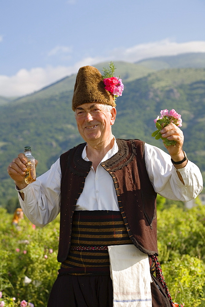 Bulgarian man in traditional costume with rose oil and roses, Rose Festival, Karlovo, Bulgaria, Europe