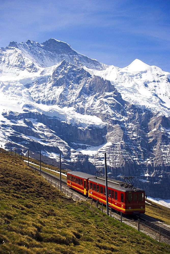 Jungfraubahn leaving station Kleine Scheidegg (2061 m), on the way to Jungfraujoch (highest railway station in Europe), Jungfrau in the background, Bernese Oberland (highlands), Canton of Bern, Switzerland