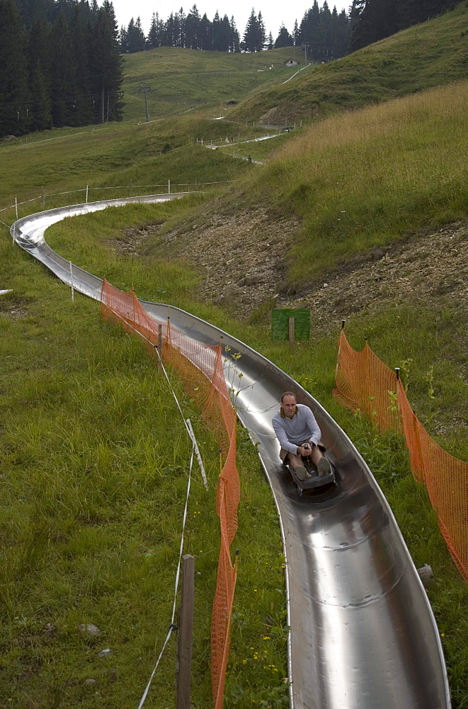 Man in summer tobbogan run, longest summer toboggan run of Switzerland, Fraekmuentegg, Pilatus (2132 m), Lucerne, Canton of Lucerne, Switzerland