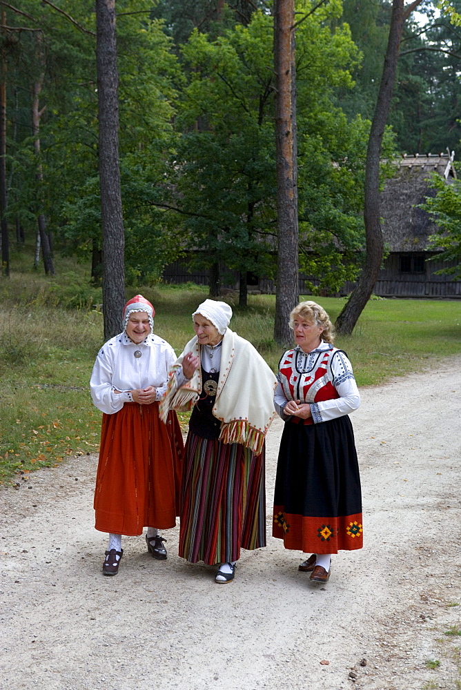 Three ladies in traditional costumes in the farm house museum of Latvia