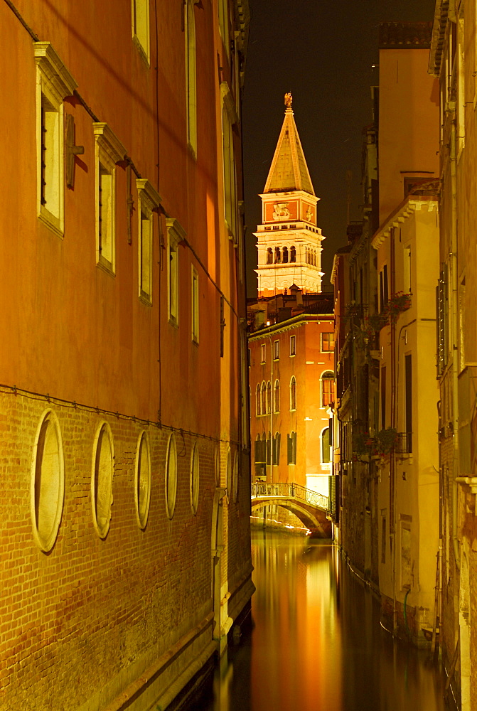 Canal between houses, bridge and spire at night shot, Venice, Venezia, Italy