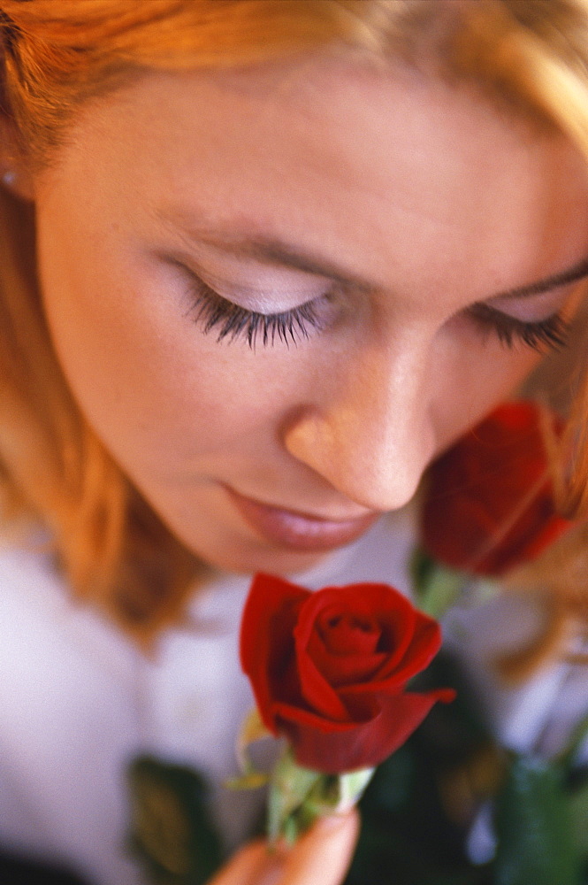 Portrait of a woman smelling a rose, Beauty