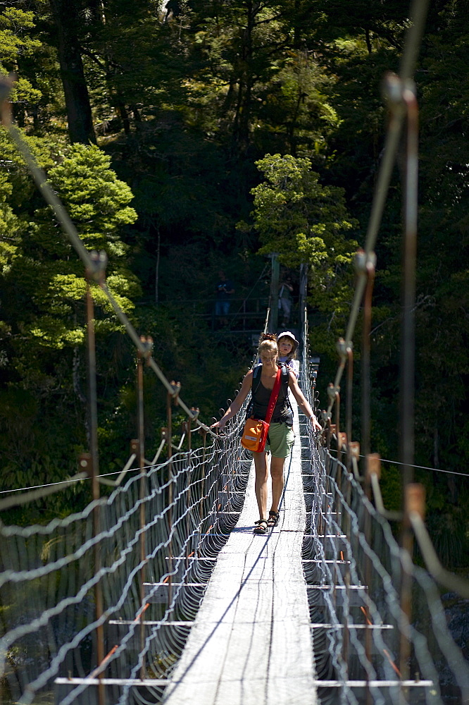 Mother with child on hanging bridge, track to Blue Pools, east of Haast Pass, Southern Alps, South Island, New Zealand