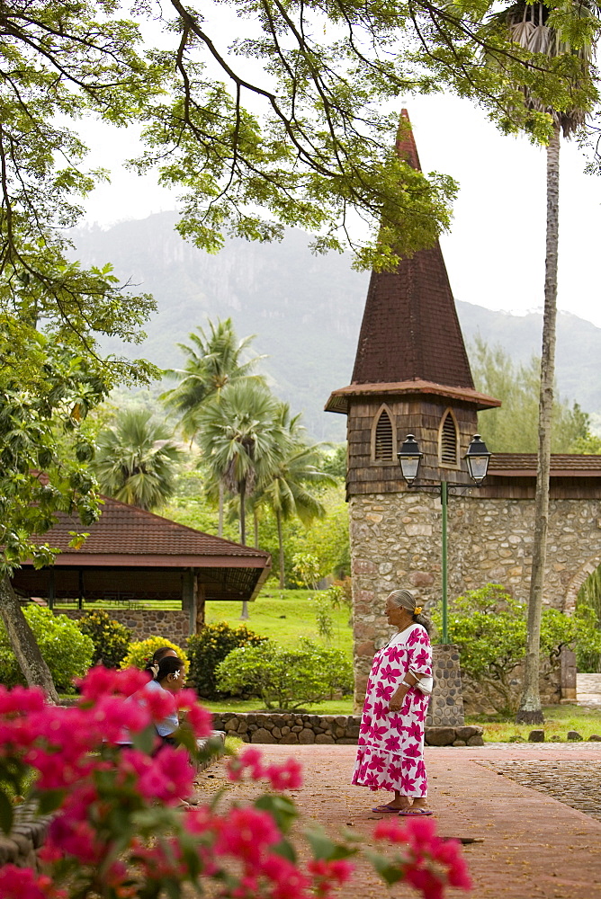 Woman talking in front of the church, Nuku Hiva, Marquesas Islands, Polynesia, Oceania