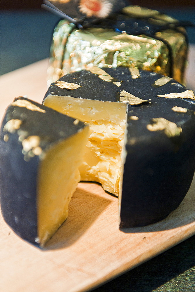 Chunk of cheese with gold leaf, De gust, South Tyrol, Italy