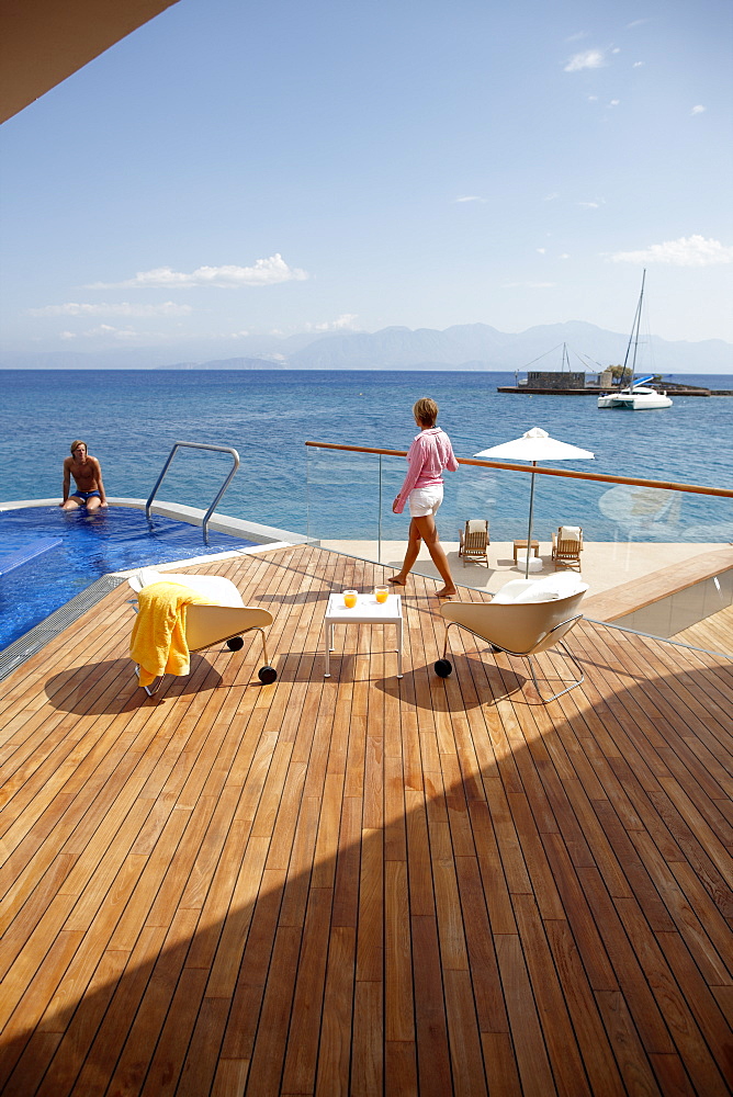 Man and woman at the pool and deck of Yachting Club Villas, Elounda Beach Resort, Elounda, Crete, Greece