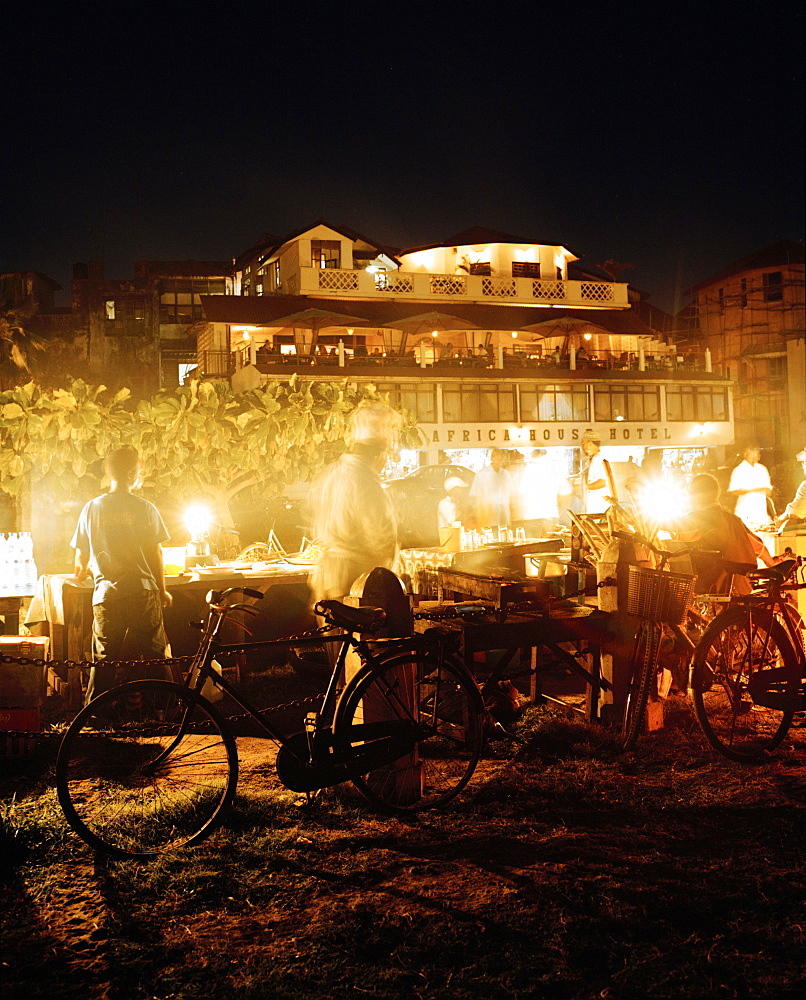 Food stalls at night on Forodhani beach, Africa House und Bar in the back, Stone Town, Zanzibar, Tanzania, East Africa