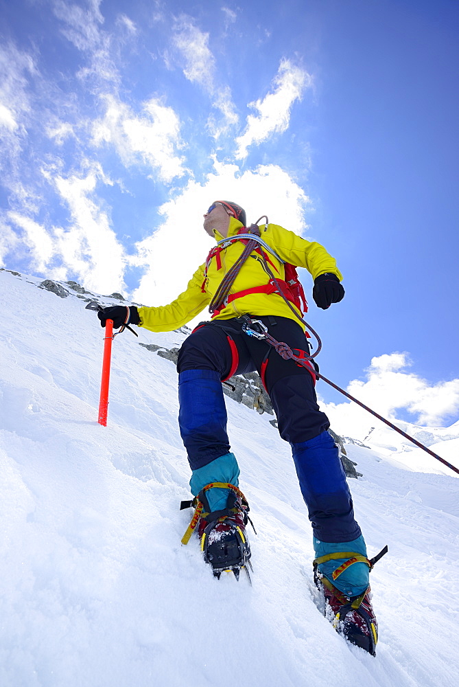 Mountaineer ascending with crampons and ice axe, Piz Palue, Grisons, Switzerland