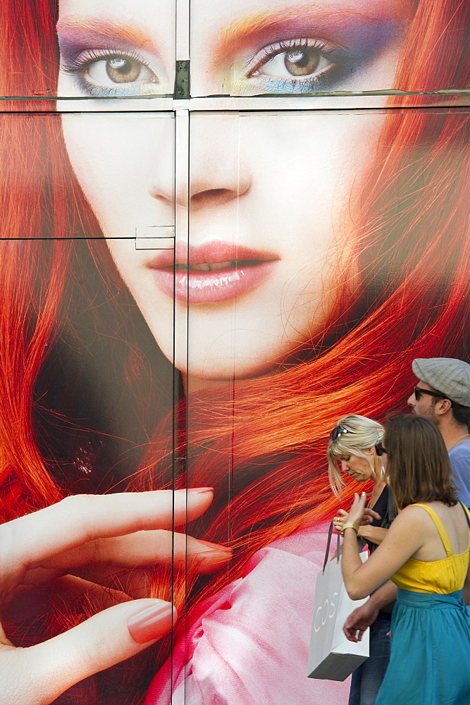 People in front of a giant poster in the shopping area, Strasbourg, Alsace, France