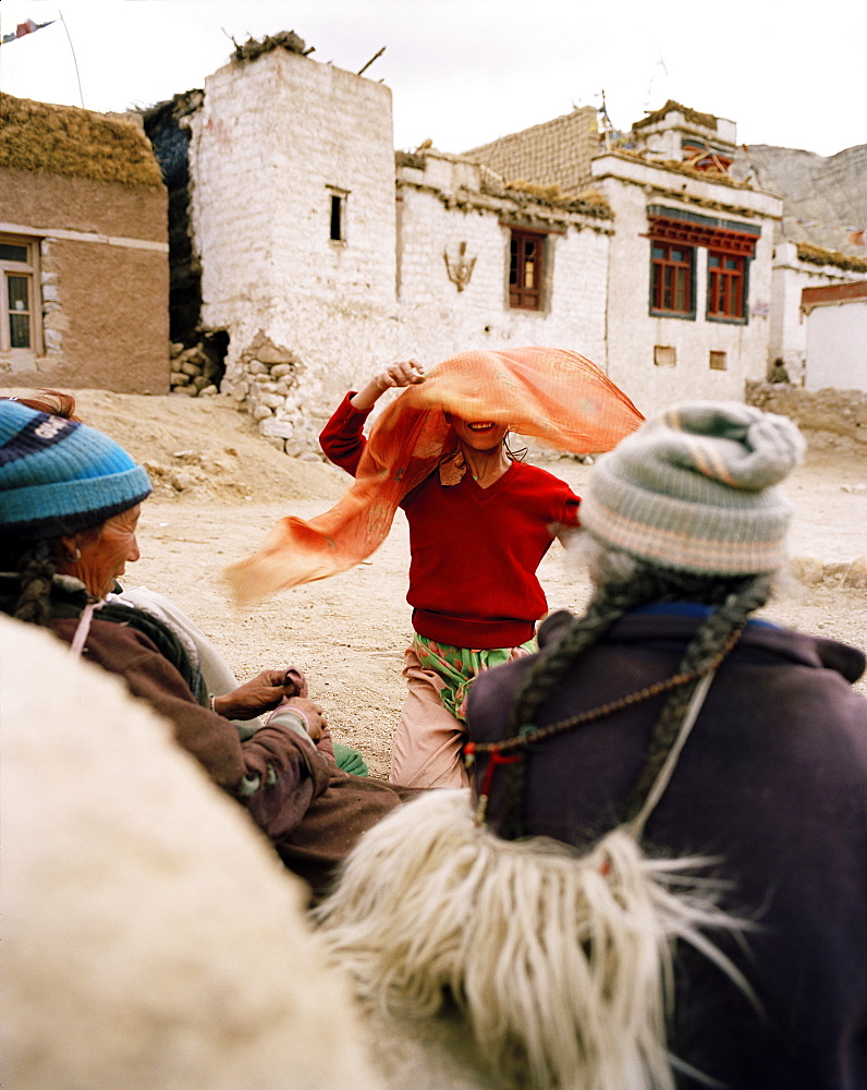 Girl banters with women in village Yangthang, Sham Trek west of Leh, Ladakh, Jammu and Kashmir, India