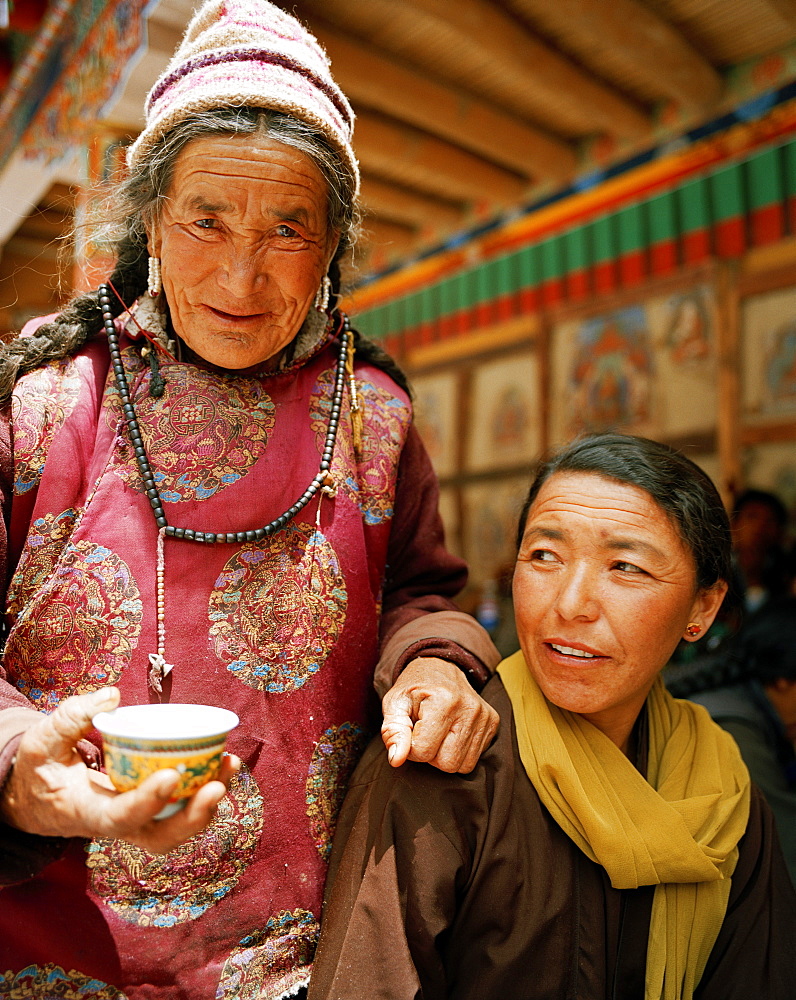 Women drinking tea in the courtyard, Hemis Festival at convent Hemis, southeast of Leh, Ladakh, Jammu and Kashmir, India