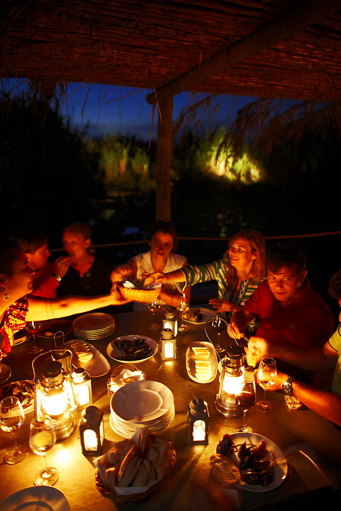 Guests having dinner on the wooden deck at night, Hotel Areias do Seixo, Povoa de Penafirme, A-dos-Cunhados, Costa de Prata, Portugal