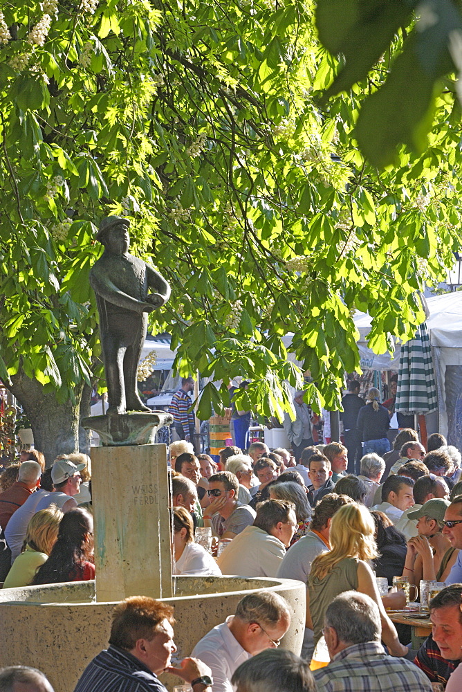 People and a fountain at beer garden at the Viktualienmarkt, Munich, Bavaria, Germany