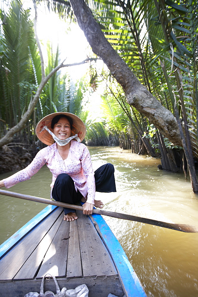 Woman canoeing tourists boats, Thoi Son island tour, My Tho, Tien Giang Province, Vietnam