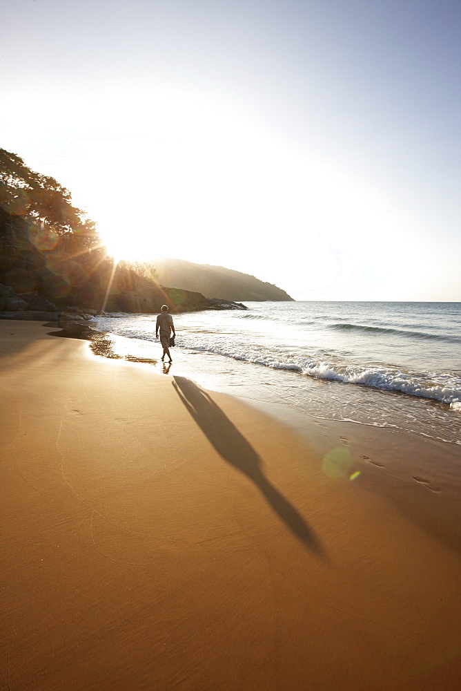 Man walking along Dam Trau beach in the evening, Con Dao Island, Con Dao National Park, Ba Ria-Vung Tau Province, Vietnam