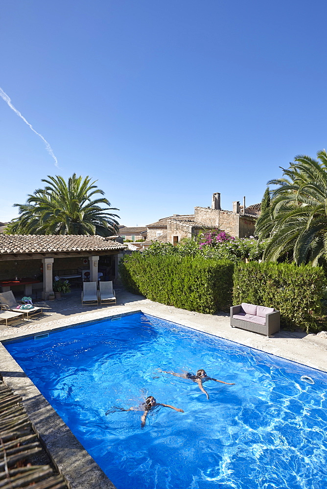 Two girls swimming in a pool, Finca, Algaida, Mallorca, Balearic Islands, Spain