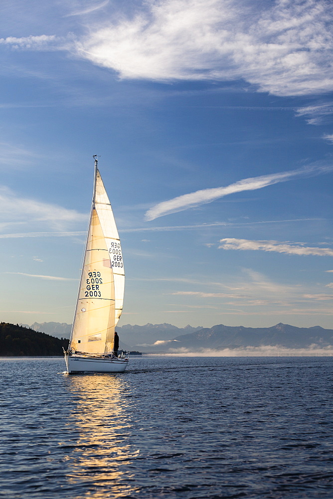 Sailing boat on Lake Starnberg, the Alps in background, Bavaria, Germany