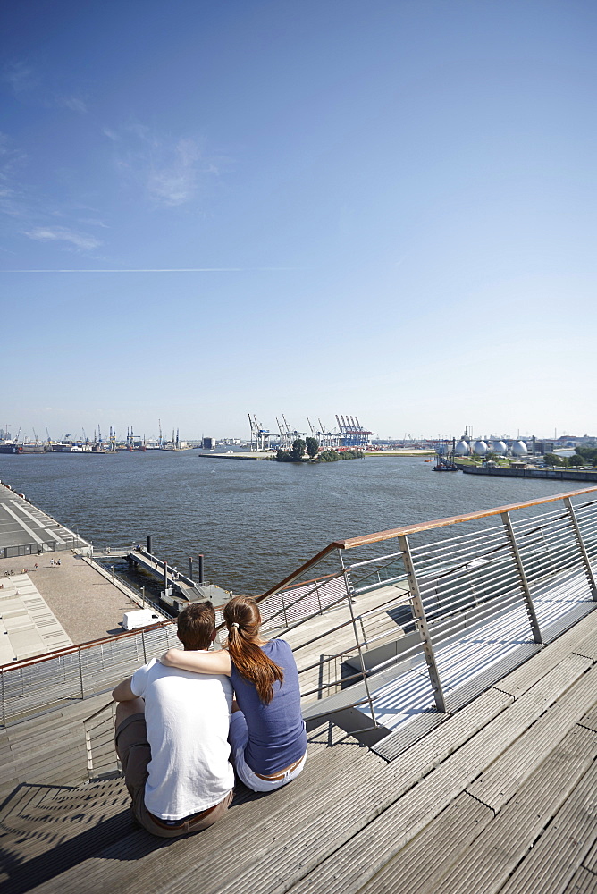 Couple on the terrace of Dockland, office building, near Altona fishing harbour, Hamburg, Germany