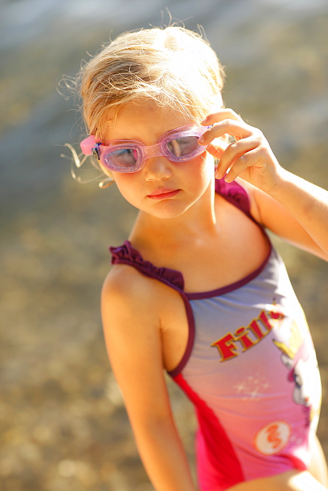 Girl 4 years wearing swimsuit and swim googles at lake Starnberg, Ammerland, Munsing, Upper Bavaria, Germany