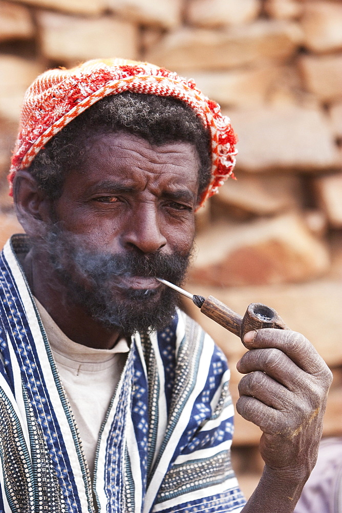 Dogon man smoking a pipe in Tireli, Mali