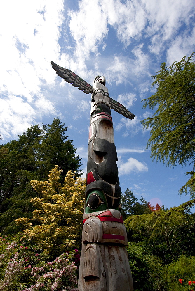 Contemporary Coast Salish totem pole carved by Doug LaFortune in Butchart Gardens, Victoria, British Columbia, Canada