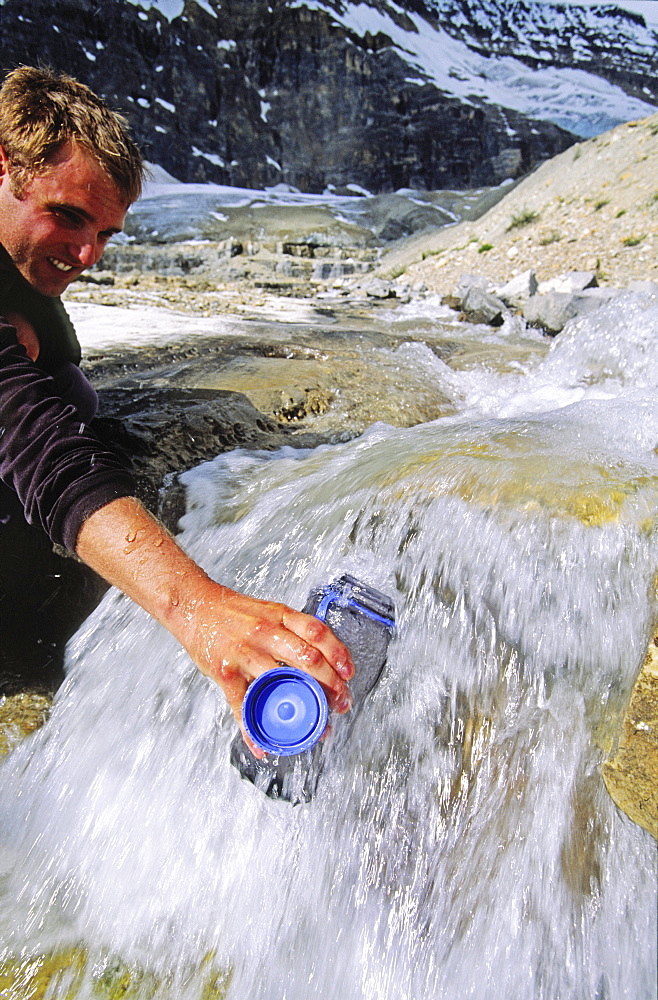 Filling a Water Bottle in a Glacial Stream, Iceline Trail, Yoho National Park, British Columbia