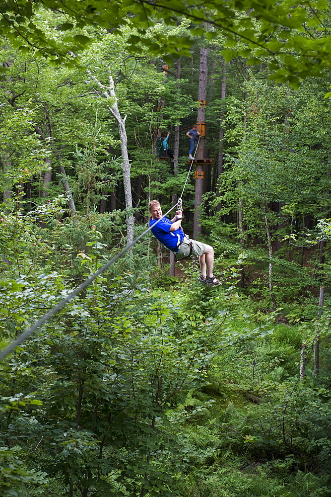 Man on a zip line between trees, Arbres en Arbres, Shawinigan, Quebec