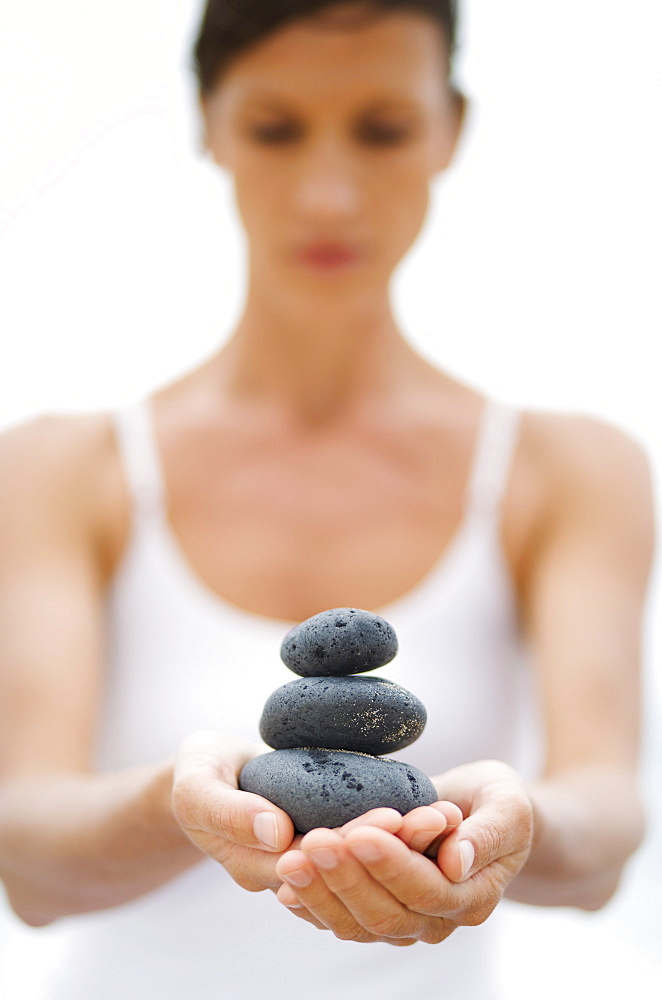 Hawaii, Woman holding stack of stones in hands.