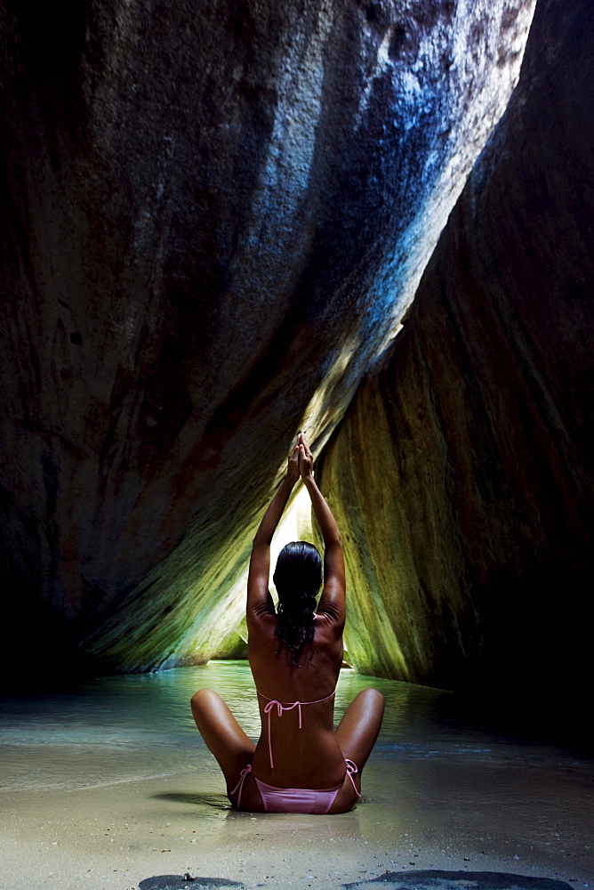 Caribbean, British Virgin Islands, Virgin Gorda, The Baths, The Crawl, Woman doing yoga in sea cave.