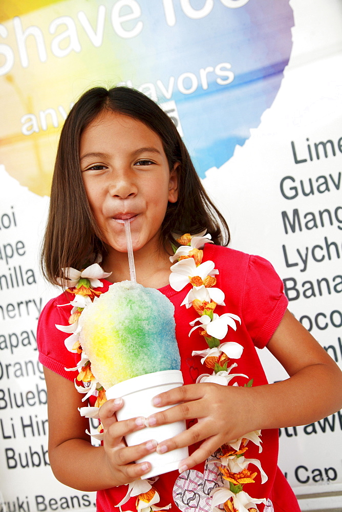 Hawaii, Oahu, Young girl drinking from a shave ice.