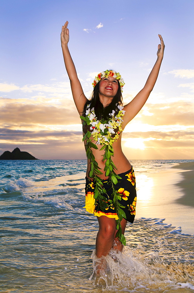 Hawaii, Oahu, Lanikai, Female hula dancer along beach shoreline at sunrise.