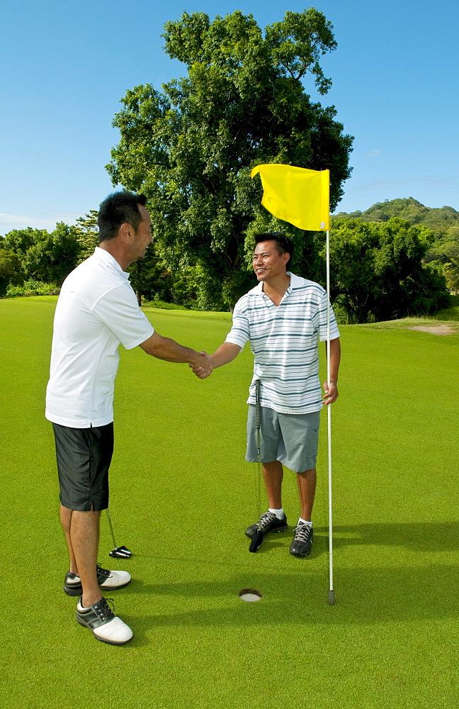 Hawaii, Oahu, Honolulu, Pali Golf Course, A local golfer congratulates his friend after making a good shot at hole 5.