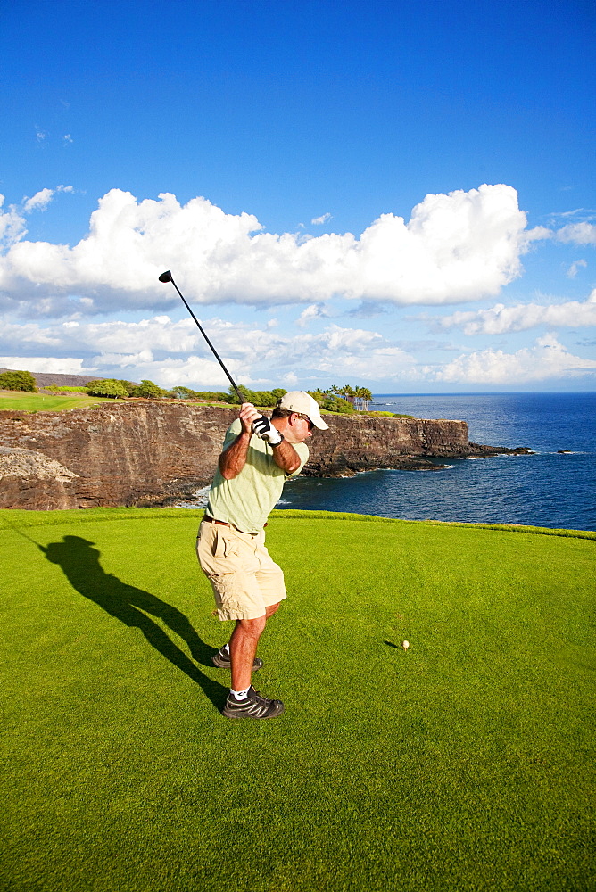 Hawaii, Lanai, Man hitting a tee shot on The Challenge at Manele golf course.