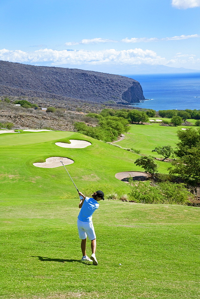 Hawaii, Lanai, Woman hitting a tee shot on The Challenge at Manele golf course.