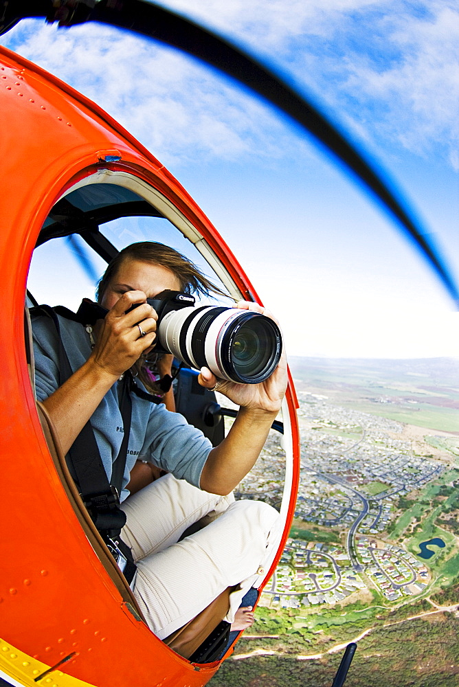 Hawaii, Maui, A female photographer shooting from a Helicopter.