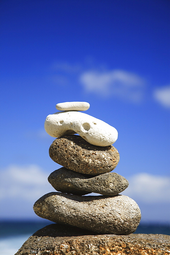 Hawaii, Oahu, Spa element of rocks stacked up against a blue sky.