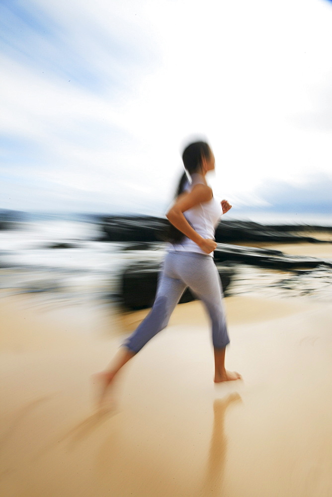 Hawaii, Oahu, Young girl on the beach running in the sand.