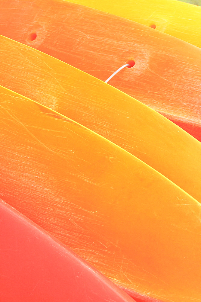 Hawaii, Oahu, Pattern shot of orange yellow Kayaks stacked on each other.