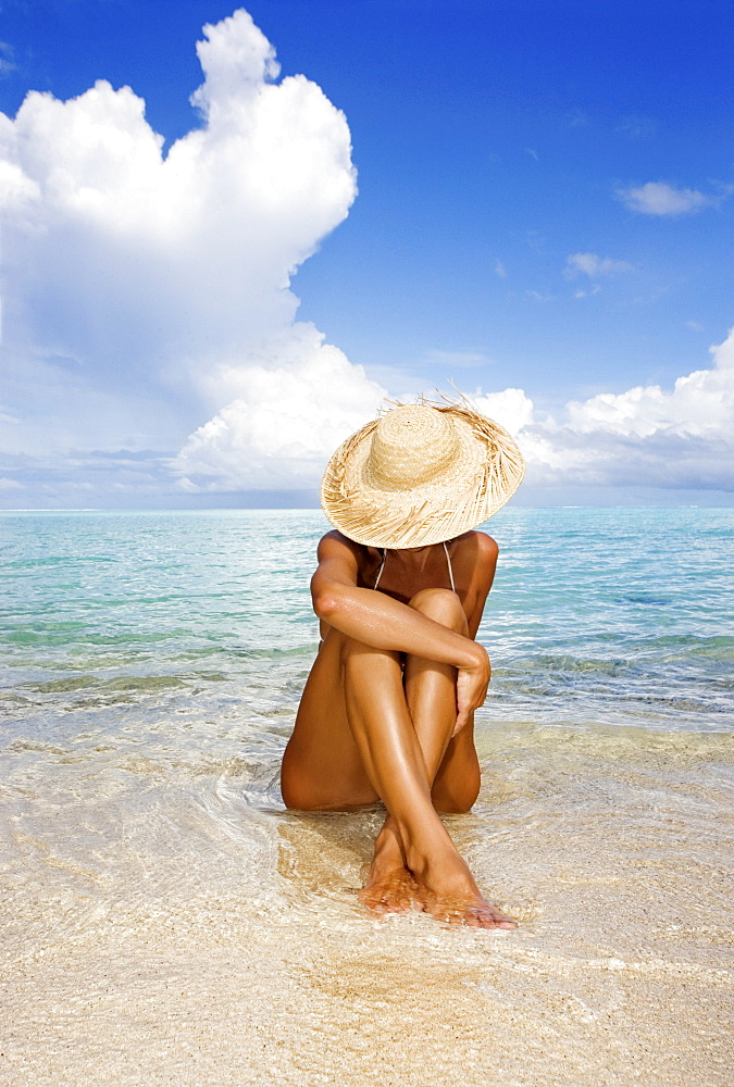 Hawaii, Woman sitting in the ocean at a remote tropical location.