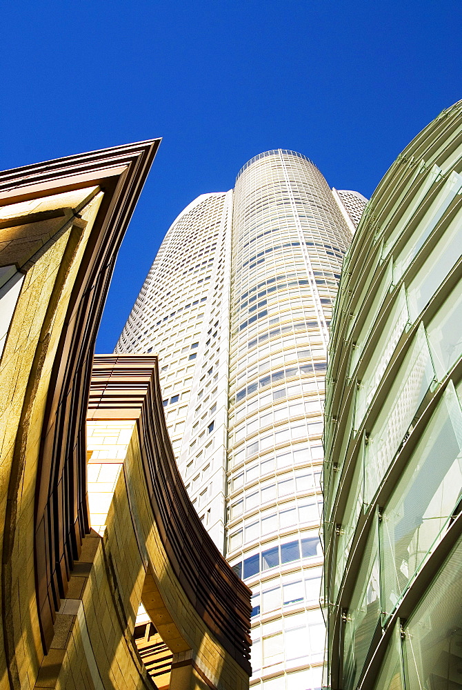 Japan, Tokyo, Roppongi Hills, upward view of Mori Tower framed by glass and stone of lower structures.