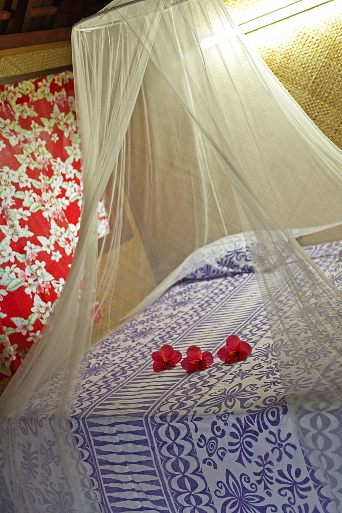 French Polynesia, Tahiti, Maupiti, hotel bedroom with flowers on bed.