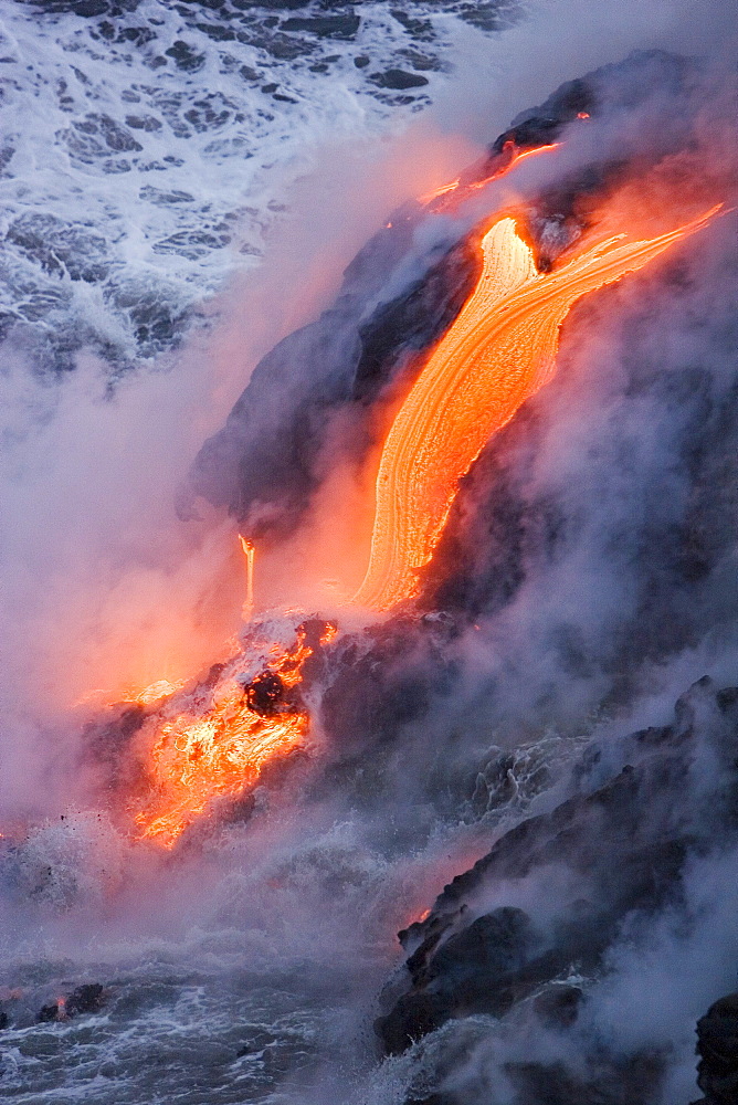 Hawaii, Big Island, near Kalapana, Pahoehoe lava flowing from Kilauea into frothy Pacific Ocean, Steam rising.