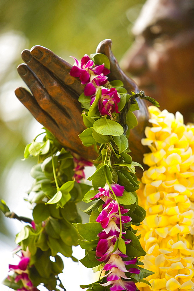 Hawaii, Oahu, Waikiki, Duke Kahanamoku statue draped with flowers.