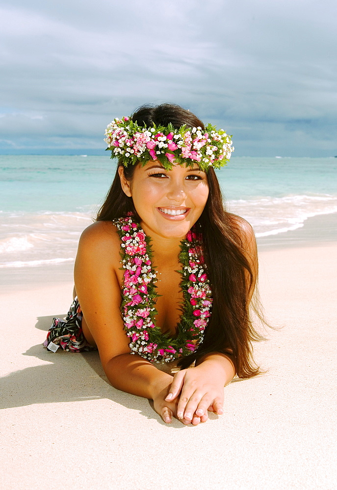 Hawaii, Oahu, Lanikai, Beautiful Hawaiian girl in haku and lei, laying on the beach.