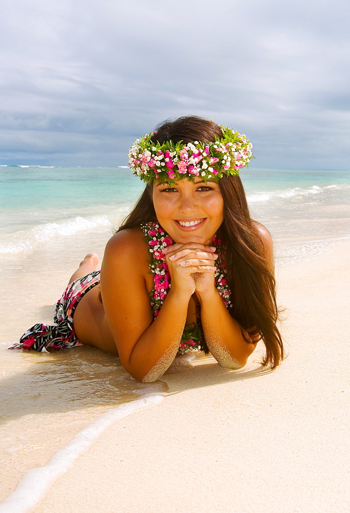 Hawaii, Oahu, Lanikai, Lovely Hawaiian girl in haku and lei, laying on the beach.