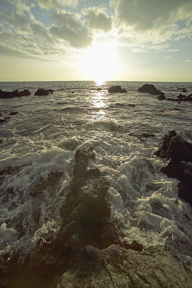 Hawaii, Big Island, Kohala Coast, Sunset and surf on rocks.