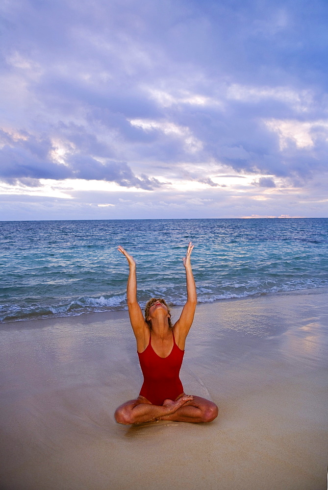 Hawaii, Oahu, Lanikai, woman doing yoga on the beach at sunrise.