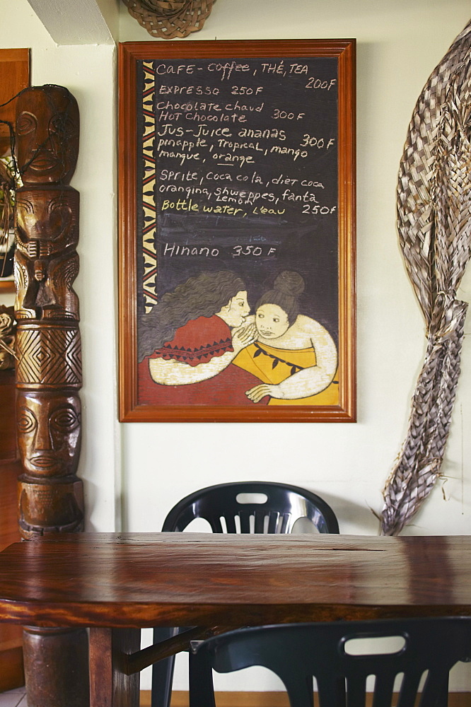 French Polynesia, Tahiti, Huahine, Inside a coffeeshop, decorative wooden table, chalkboard menu on wall